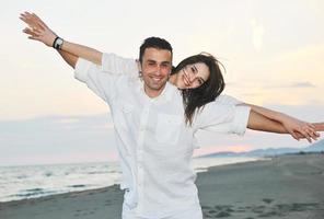 happy young couple have fun on beach photo