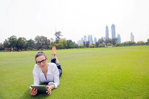 hermosa mujer joven con tableta en el parque foto