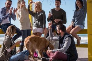 grupo de amigos divirtiéndose el día de otoño en la playa foto