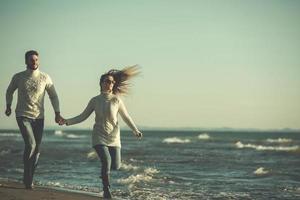 Loving young couple on a beach at autumn sunny day photo