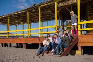 grupo de amigos divirtiéndose el día de otoño en la playa foto