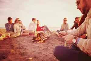 Friends having fun at beach on autumn day photo