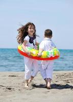 Grupo de niños felices jugando en la playa foto