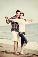 happy young couple have fun on beach photo