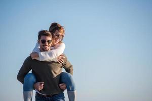 pareja divirtiéndose en la playa durante el otoño foto