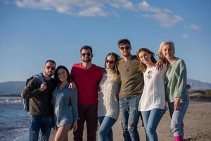 portrait of friends having fun on beach during autumn day photo