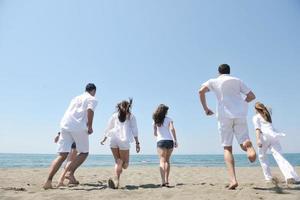 grupo de gente feliz divertirse y correr en la playa foto