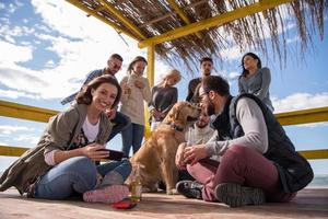 Group of friends having fun on autumn day at beach photo