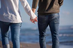 Loving young couple on a beach at autumn sunny day photo