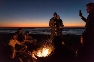 Friends having fun at beach on autumn day photo