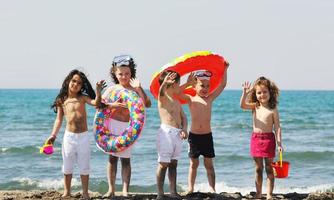 grupo infantil divertirse y jugar con juguetes de playa foto