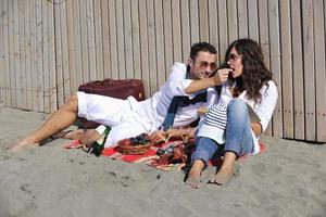 young couple enjoying  picnic on the beach photo