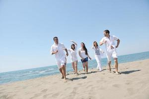 grupo de gente feliz divertirse y correr en la playa foto