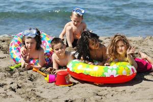 grupo infantil divertirse y jugar con juguetes de playa foto