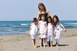 group portrait of childrens with teacher on beach photo