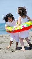 Grupo de niños felices jugando en la playa foto