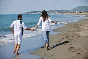 happy young couple have fun at beautiful beach photo