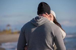 Loving young couple on a beach at autumn sunny day photo