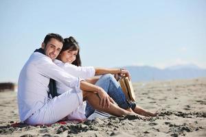 young couple enjoying  picnic on the beach photo