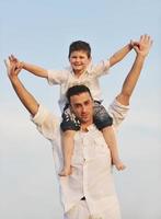 familia joven feliz divertirse en la playa foto