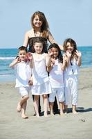 retrato de grupo de niños con profesor en la playa foto