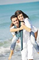 feliz pareja joven divertirse en la hermosa playa foto