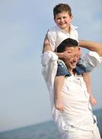 happy father and son have fun and enjoy time on beach photo