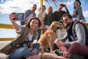 Group of friends having fun on autumn day at beach photo