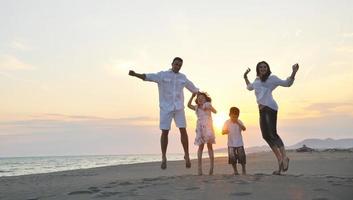 happy young family have fun on beach at sunset photo