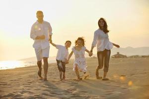 familia joven feliz divertirse en la playa foto