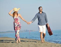 pareja en la playa con bolsa de viaje foto