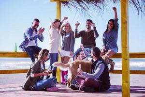 grupo de amigos divirtiéndose el día de otoño en la playa foto