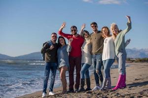 portrait of friends having fun on beach during autumn day photo