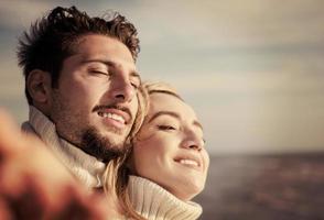 Loving young couple on a beach at autumn sunny day photo