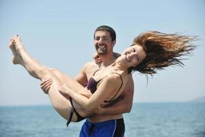 feliz pareja joven divertirse en la playa foto