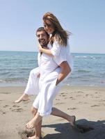 feliz pareja joven divertirse en la playa foto