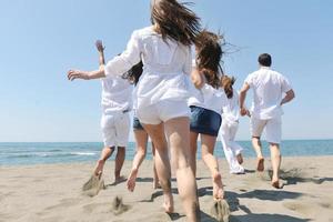 happy people group have fun and running on beach photo