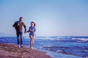 Loving young couple on a beach at autumn sunny day photo