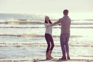 amorosa pareja joven en una playa en el día soleado de otoño foto