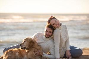 Couple with dog enjoying time on beach photo