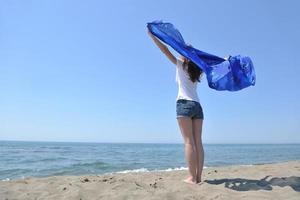 beautiful young woman on beach with scarf photo