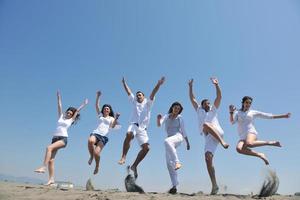 grupo de gente feliz divertirse y correr en la playa foto