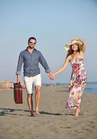 pareja en la playa con bolsa de viaje foto
