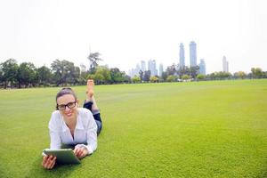 Beautiful young woman with  tablet in park photo