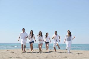 grupo de gente feliz divertirse y correr en la playa foto