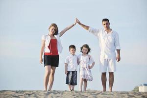 family on beach showing home sign photo