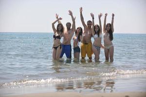 grupo de gente feliz divertirse y correr en la playa foto