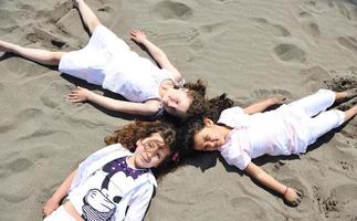 Grupo de niños felices jugando en la playa foto