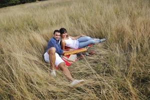 happy couple enjoying countryside picnic in long grass photo