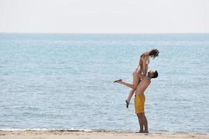 happy young couple have fun on beach photo